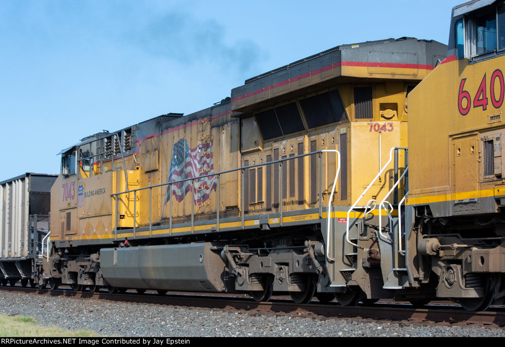 UP 7043 trails on a westbound rock train